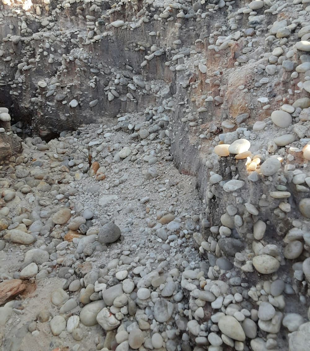 Excavated trench in stony soil