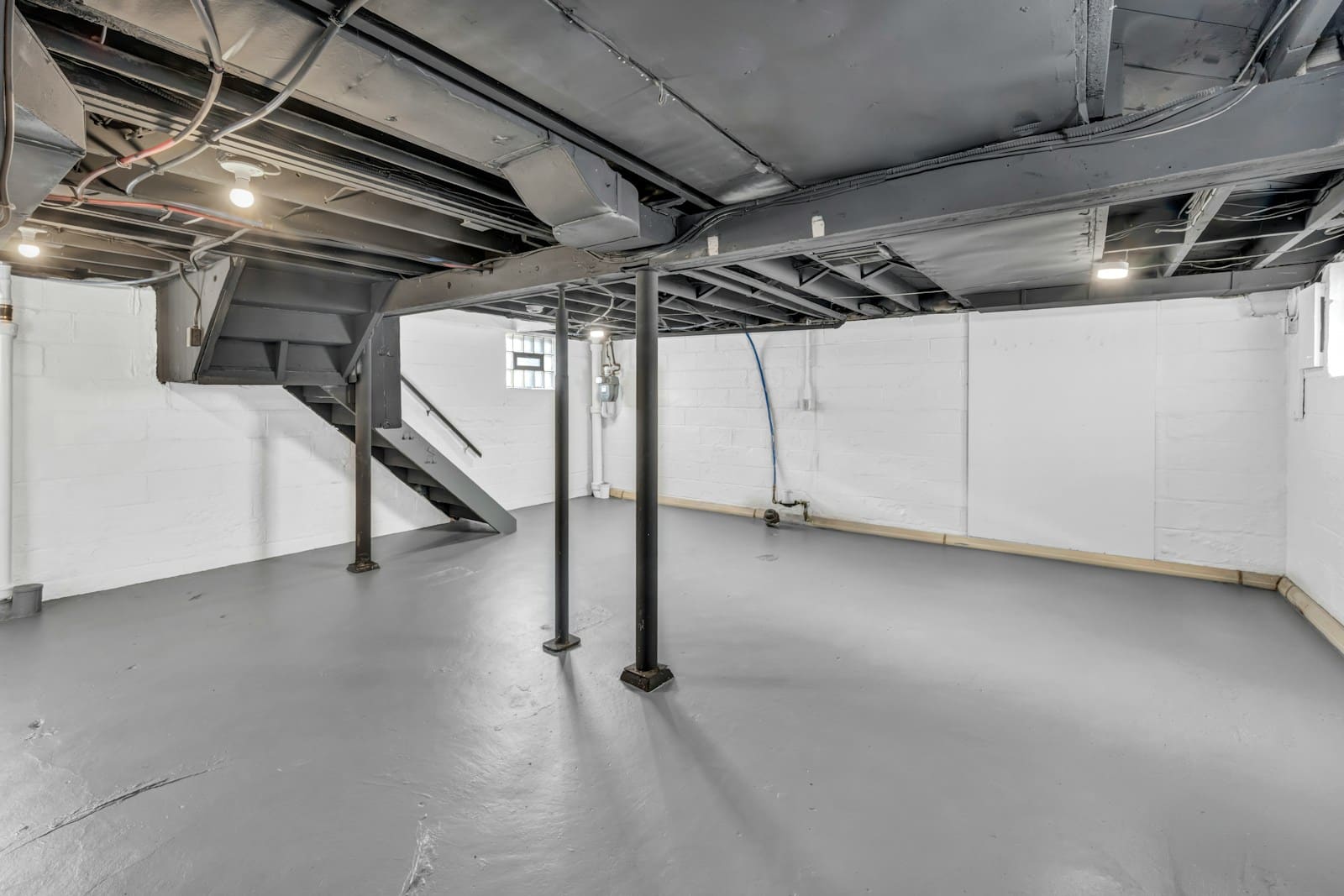 Clean unfinished basement with painted block walls
